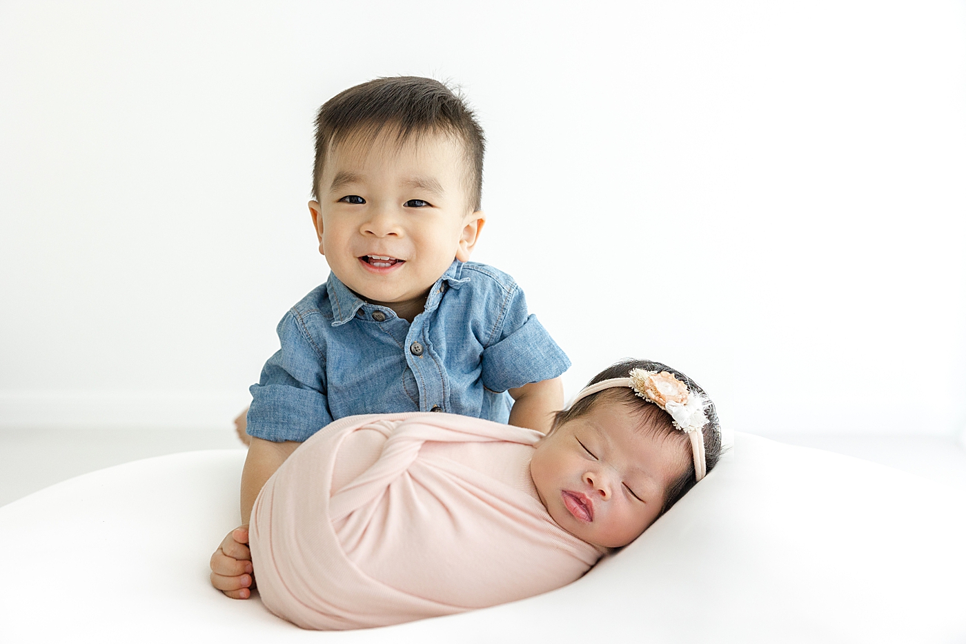Big brother smiling with his newborn baby sister | Image by Sana Ahmed