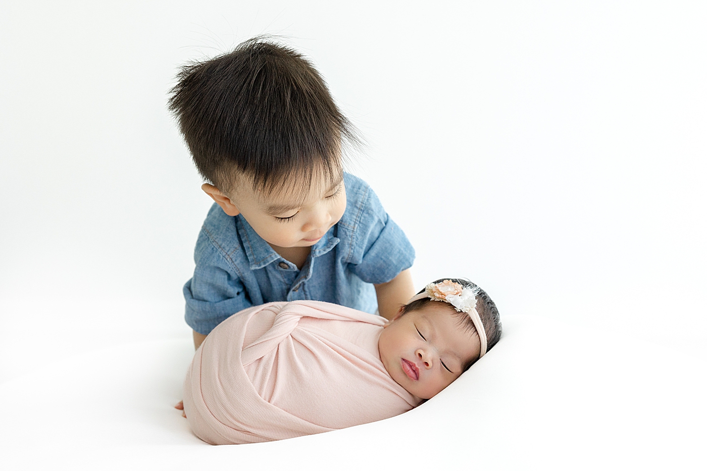 Big brother looking at his newborn baby sister | Image by Sana Ahmed