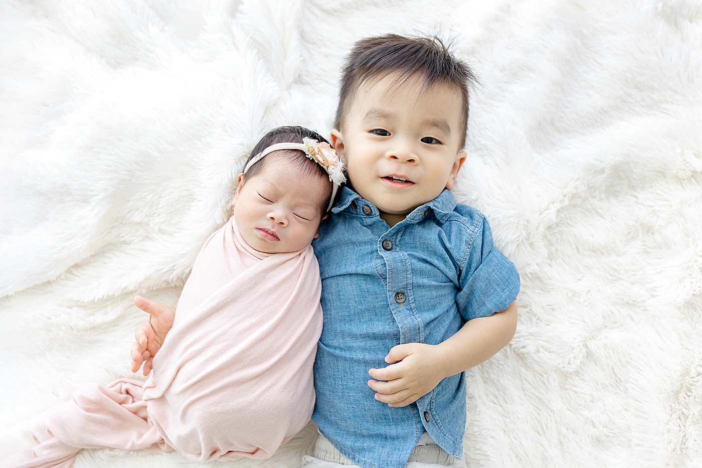 Big brother holding his baby sister during her Newborn sessions with siblings | Image by Sana Ahmed
