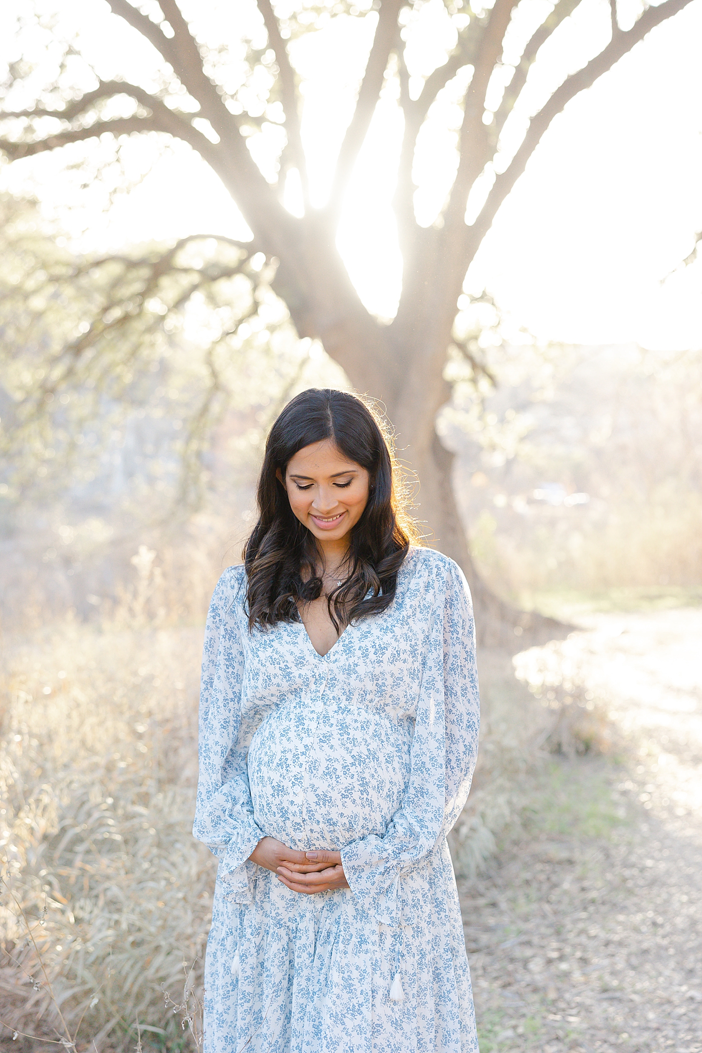 Mom to be in blue dress holding her belly | Images by Sana Ahmed 