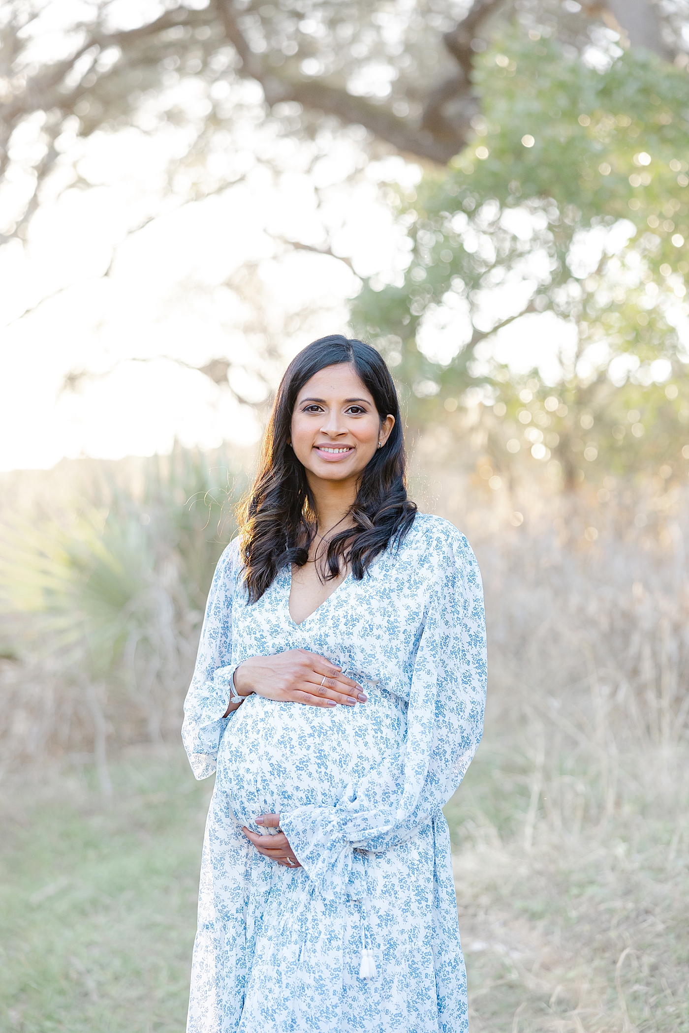 Mom to be in a blue floral dress holding her belly | Images by Sana Ahmed 