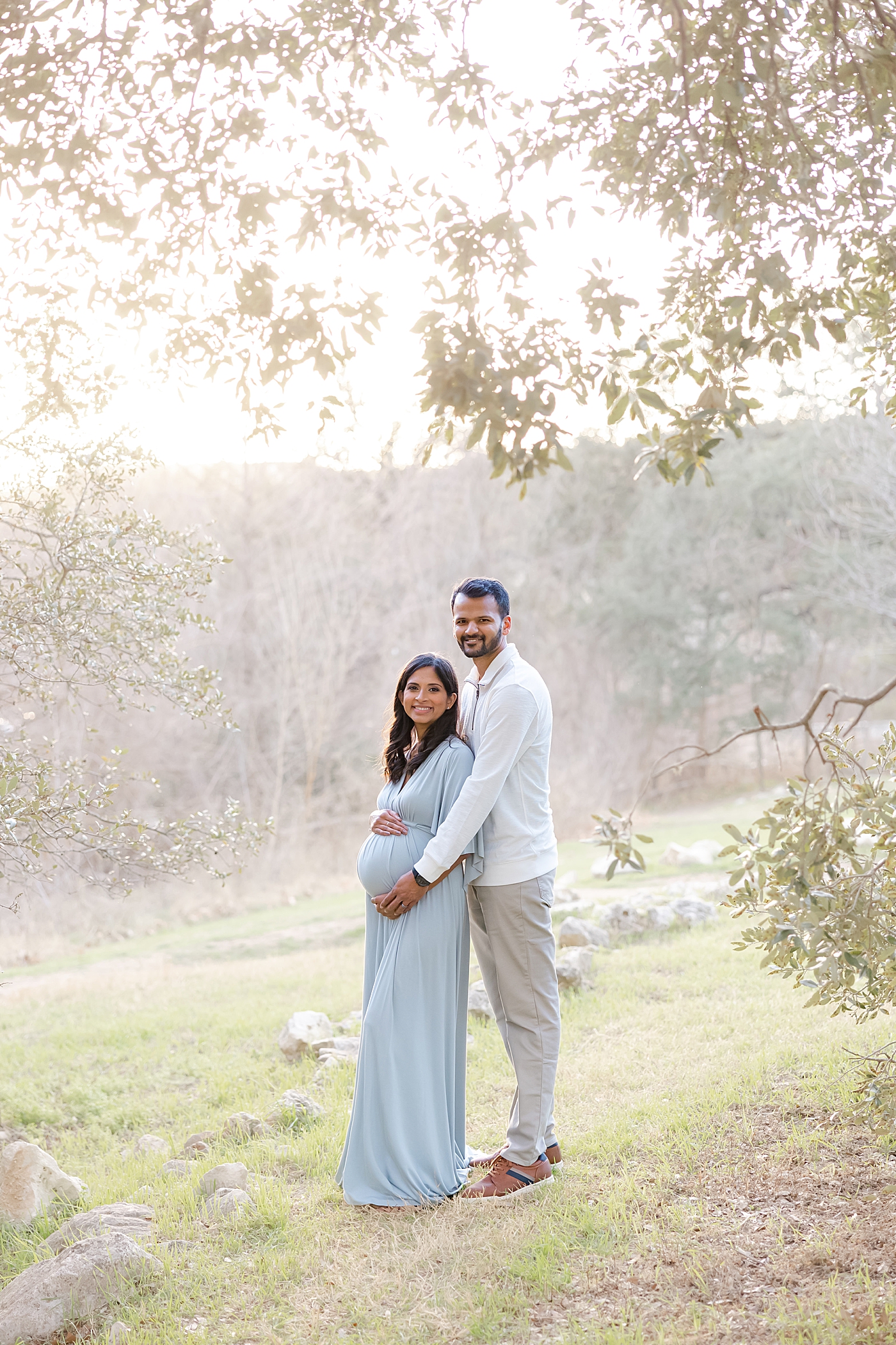 Mom and dad to be in a field during their Austin Maternity Session| Images by Sana Ahmed 