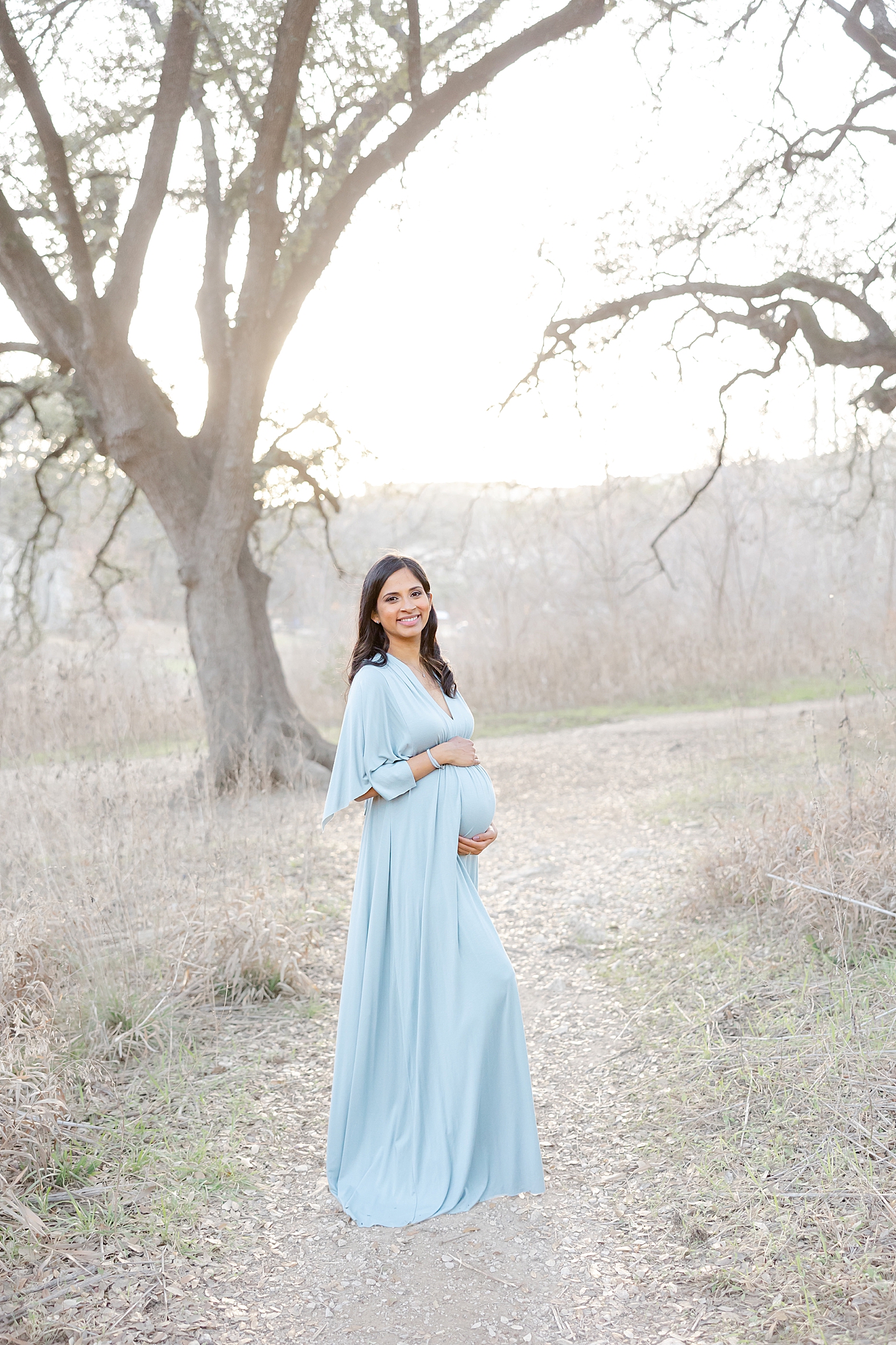 Mom to be in a blue dress holding her belly | Images by Sana Ahmed 