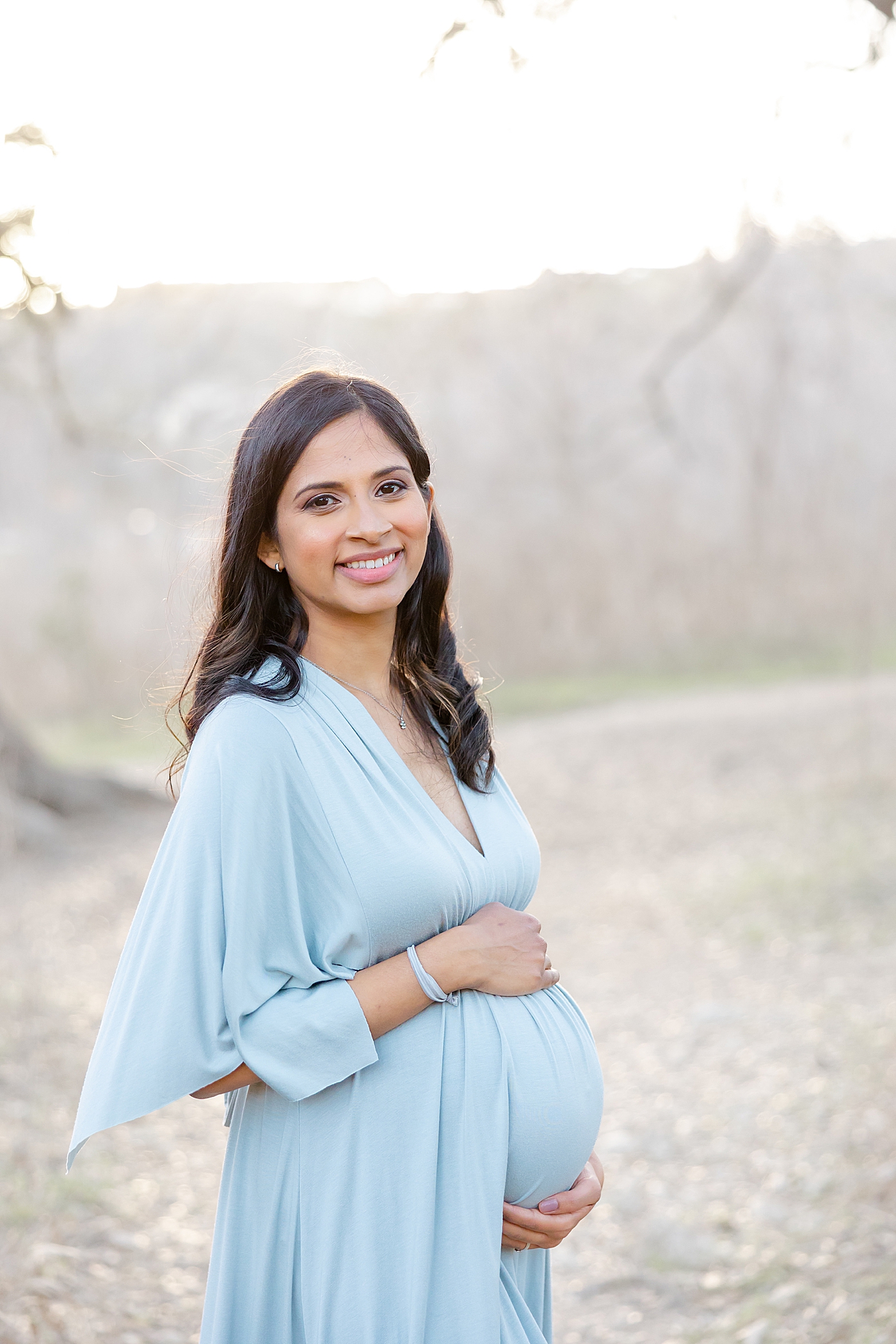 Mom to be in a blue dress smiling | Images by Sana Ahmed 