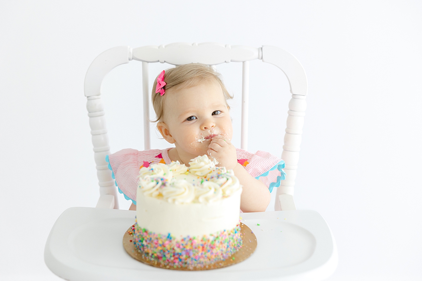 Baby girl sitting in a highchair eating a cake | Image by Sana Ahmed