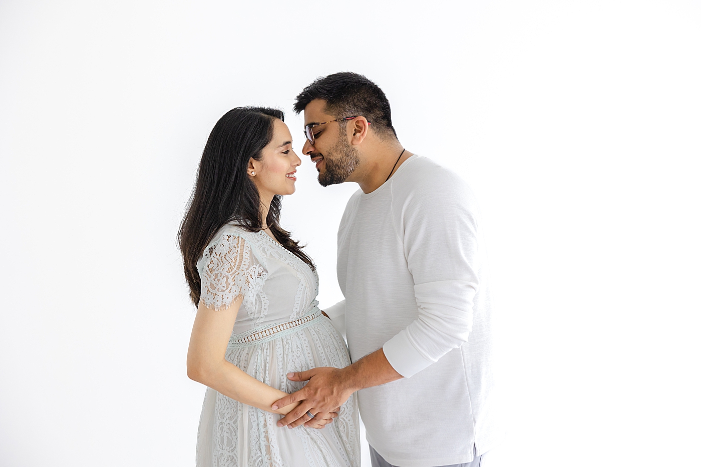 Mom and dad to be holding mom's belly | Image by Sana Ahmed Photography
