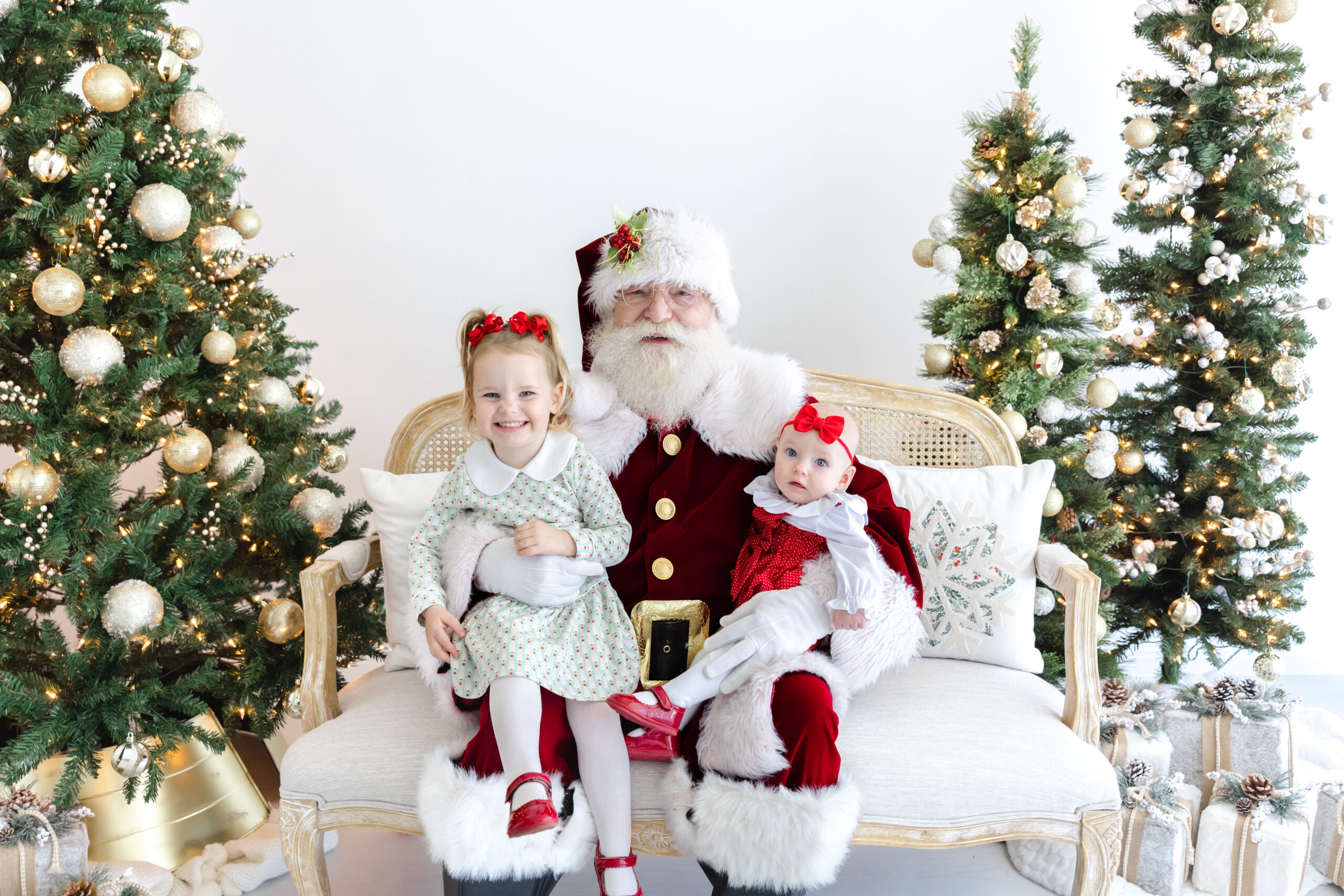 Two little girls sitting with santa during photo session | Image by Sana Ahmed