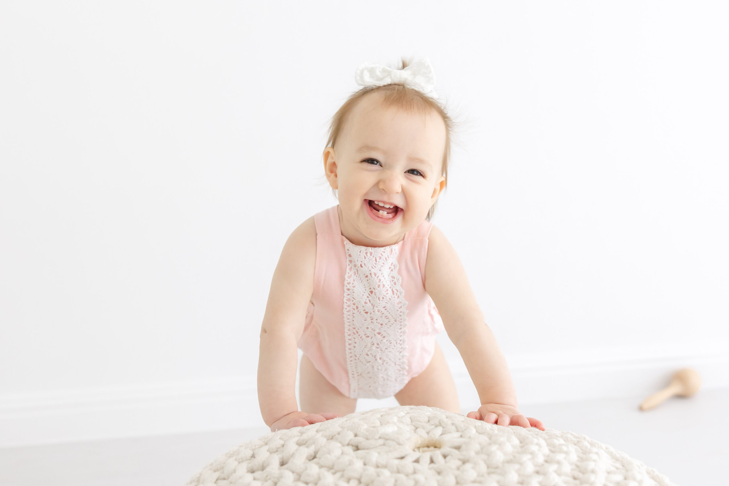 Baby girl in pink jumpsuit smiling | Image by Sana Ahmed Photography